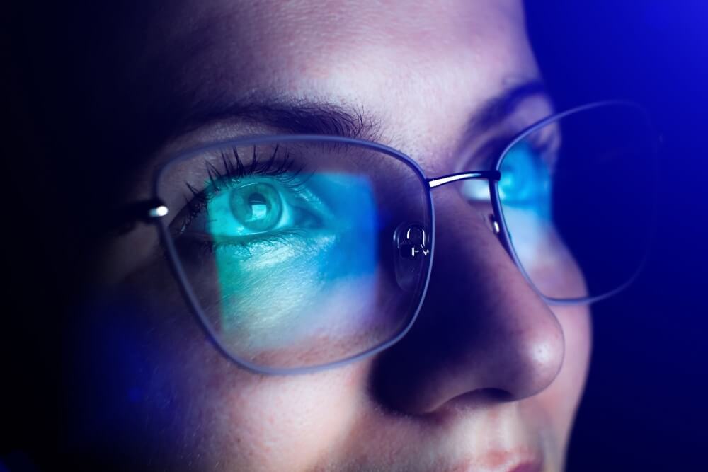 lady with glasses bathed in blue light
