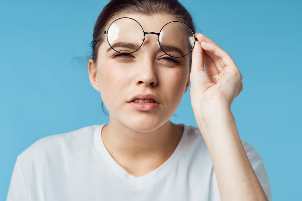 woman raising her eye glasses checking her vision