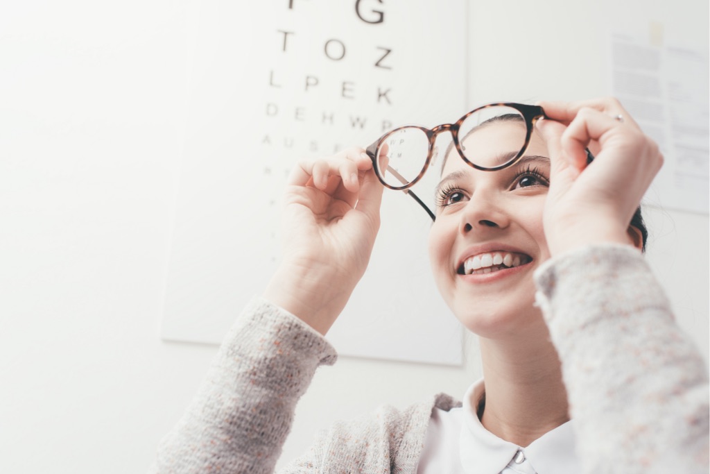 woman taking glasses off